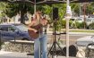Singer-songwriter with an acoustic guitar performing under a tent at West Railway Plaza in Downtown Abbotsford